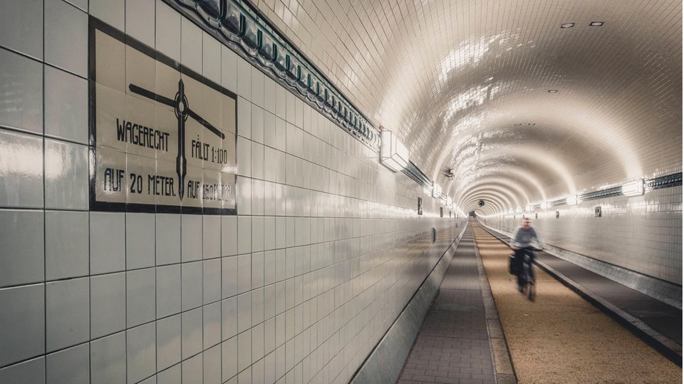 Fahrradfahrer fährt durch den alten Elbtunnel Fahrradfahrer fährt durch den alten Elbtunnel