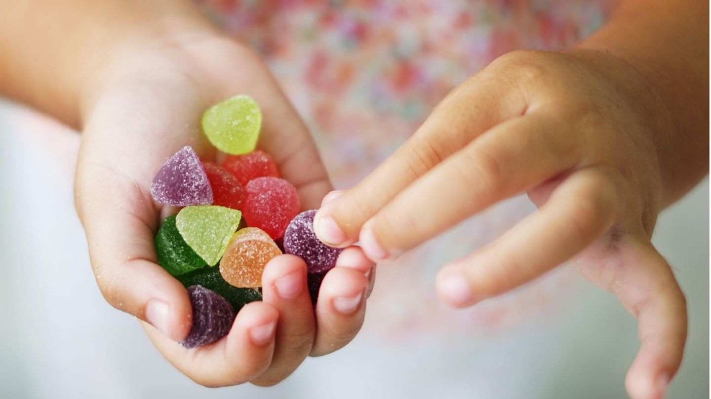 Kleinkind hält gezuckerte Geleebonbons in der Hand