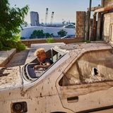 Kinder spielen in den Trümmern, dahinter die Ruine des am 4. August 2020 zerstörten Getreidesilos im Hafen