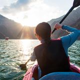 Frau fährt mit dem Kayak über den großen Hatta-Stausee im Abendlicht