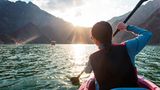 Frau fährt mit dem Kayak über den großen Hatta-Stausee im Abendlicht