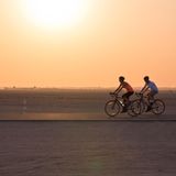 Zwei Radfahrer fahren über den Al Qudra Cycling Track in der Wüste Dubais