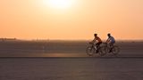 Zwei Radfahrer fahren über den Al Qudra Cycling Track in der Wüste Dubais