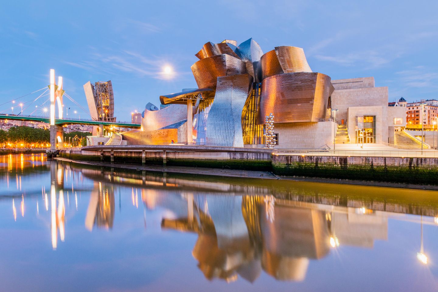 Bilbao mit Guggenheim Museum Es liegt wie ein Schiff auf dem Trockenen über den Flussufern des Nervión und schiebt sich mit einer Galerie unter die benachbarte Brücke: das 1997 eröffnete Guggenheim-Museum für moderne und zeitgenössische Kunst. Mit dem titanüberzogenen Bau nahm Architekt Frank O. Gehry seinerzeit die Zukunft vorweg. Doch Bilbao hat noch mehr zu bieten. Sehenswert sind auch die Altstadt, die Flusspromenade, die Markthalle, das Museum der Schönen Künste, die Basilika Begoña und sogar das Fußballstadion. Auf dem Rasen von Athletic Bilbao dürfen nur Ballkünstler spielen, die aus dem Baskenland stammen oder dort ausgebildet wurden. Das zeugt von Selbstbewusstsein und schafft Identifikation.