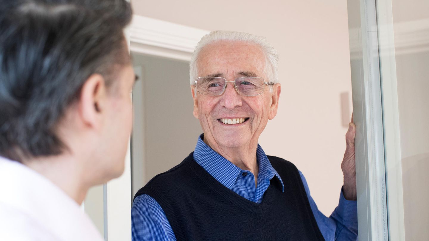 Senior mit Verkäufer an der Haustür