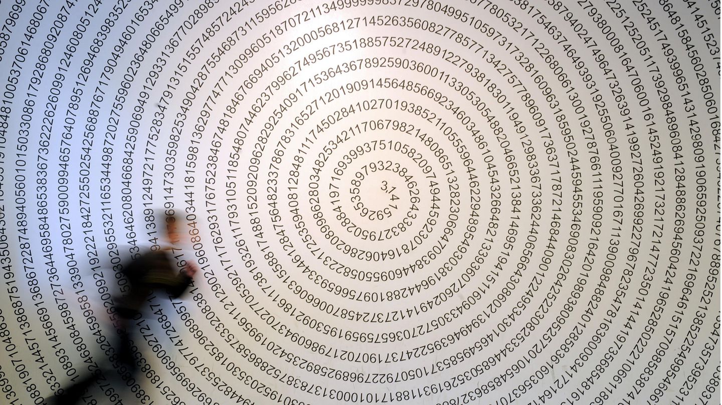 Ein Schulkind läuft im Mitmachmuseum «Mathematikum» in Gießen an der auf eine Wand geschriebenen Kreiszahl Pi vorbei