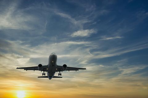 Ein Flugzeug fliegt am Himmel im Sonnenuntergang