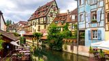 Bunte Fachwerkhäuser säumen das Flussufer in Colmar