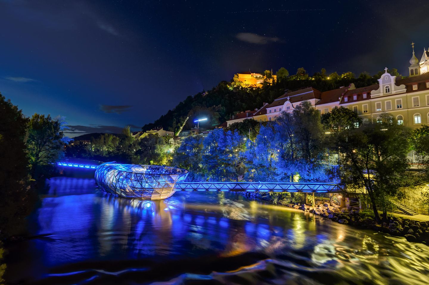 Blick auf die beleuchtete Murinsel im Graz