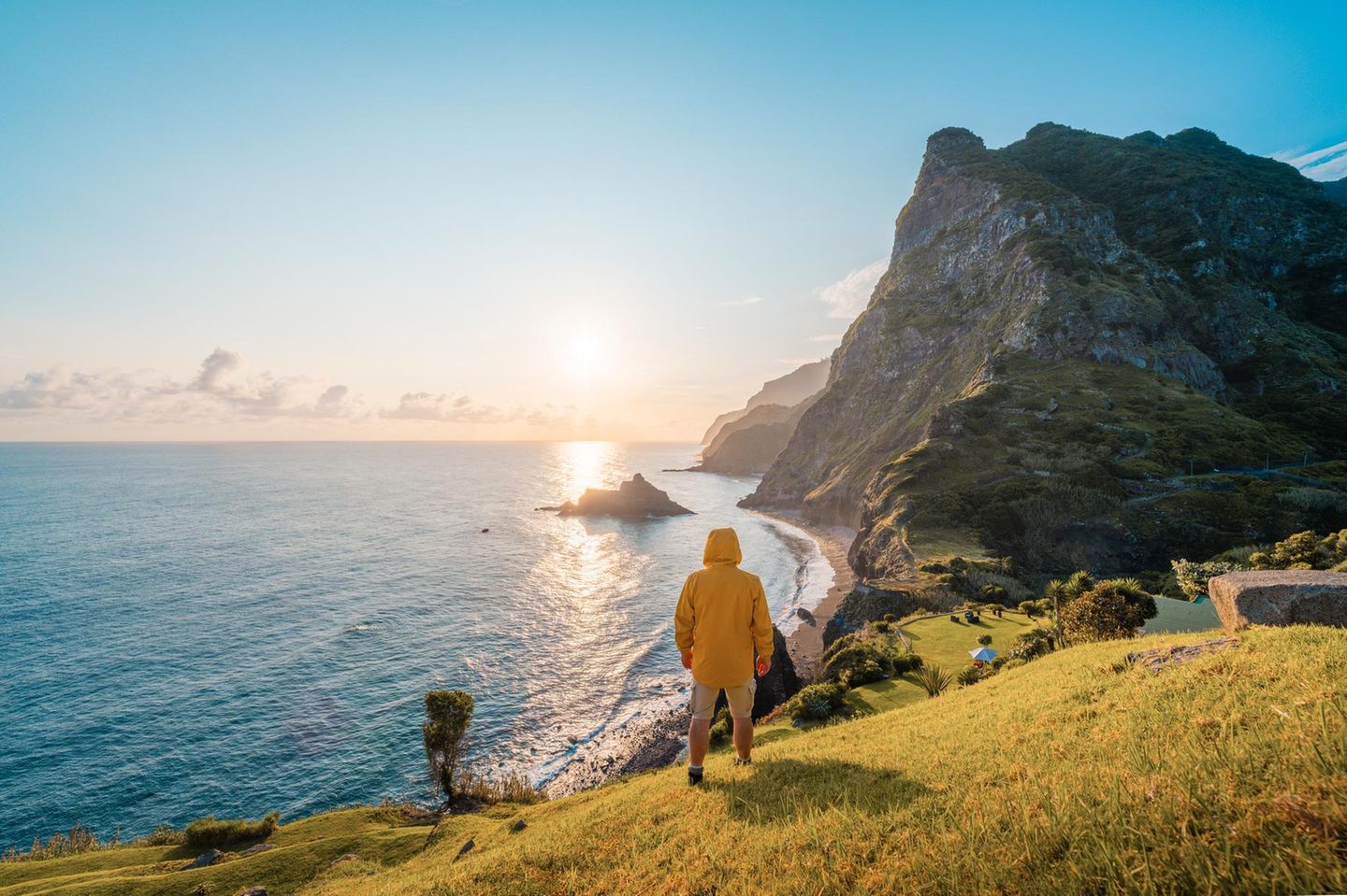 Eine Person, die bei Sonnenuntergang auf einer Klippe in Madeira, Portugal, steht