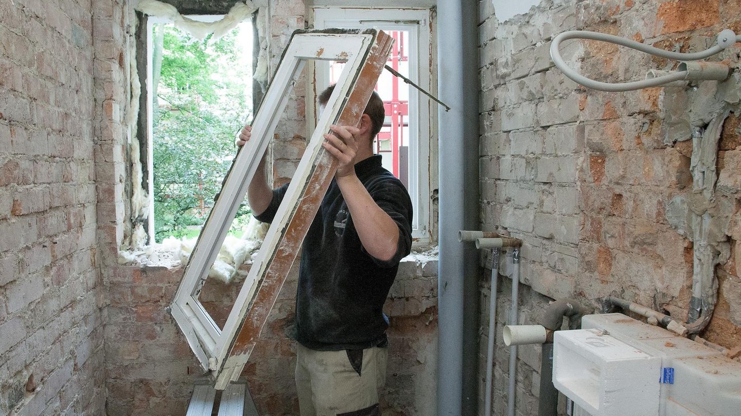Mann setzt neues fenster in ein Haus ein