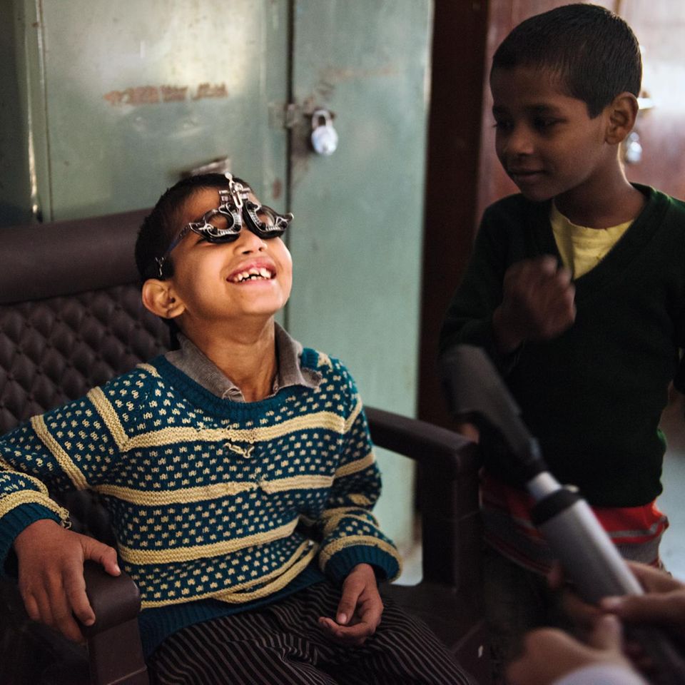 Indien, Delhi, Untersuchung in einem Waisenheim für Jungen Dieser Junge in einem Waisenhaus amüsiert sich über den sonderbaren Apparat auf seiner Nase. Wie viele indische Kinder ist er noch nie bei einem Augenarzt gewesen. Sehbehinderungen bleiben oft unbehandelt