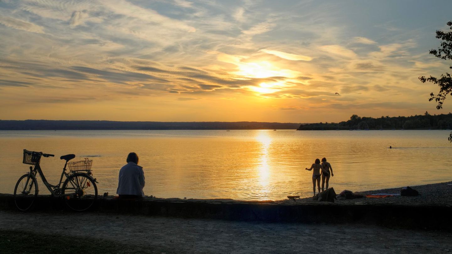 Frau sitzt neben ihrem Fahhrad am Ammersee