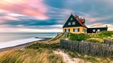 Haus am Strand bei buntem Sonnenuntergang in Skagen in Dänemark