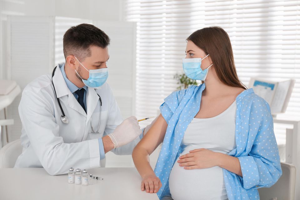 Arzt impft Schwangere gegen Covid-19
