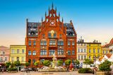 Blick auf das gothische Rathaus umgeben von bunten Häusern in Chojnice