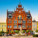 Blick auf das gothische Rathaus umgeben von bunten Häusern in Chojnice