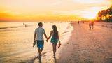 Glückliche Menschen am Fort Myers Beach in Florida bei Sonnenuntergang