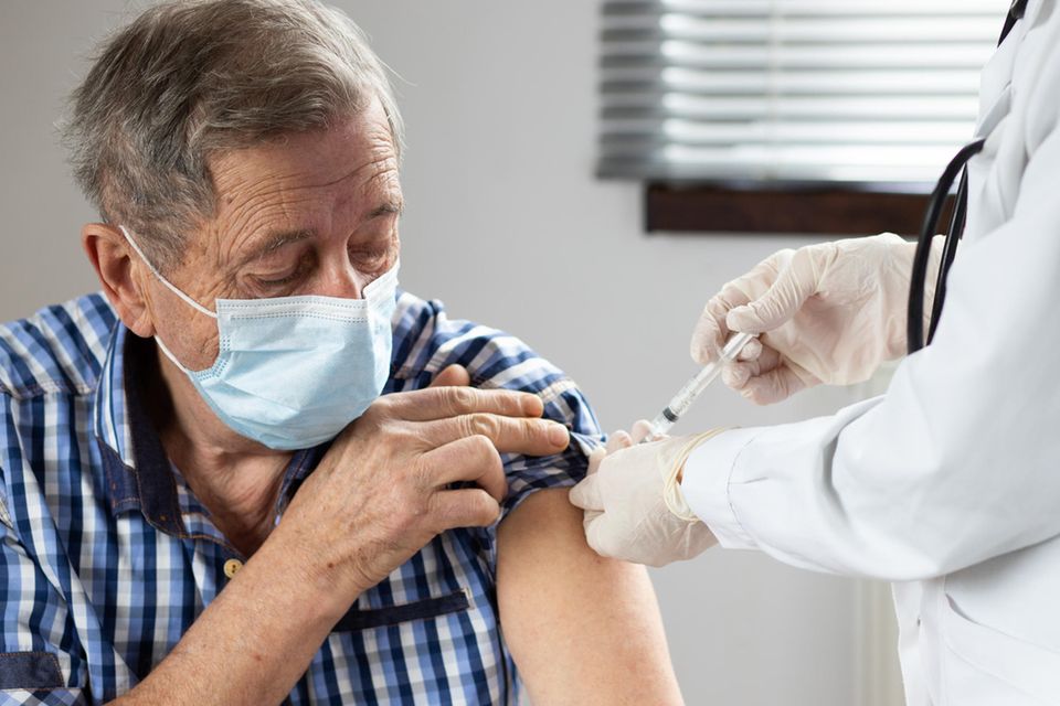 Mann wird in den Arm gegen Grippe geimpft