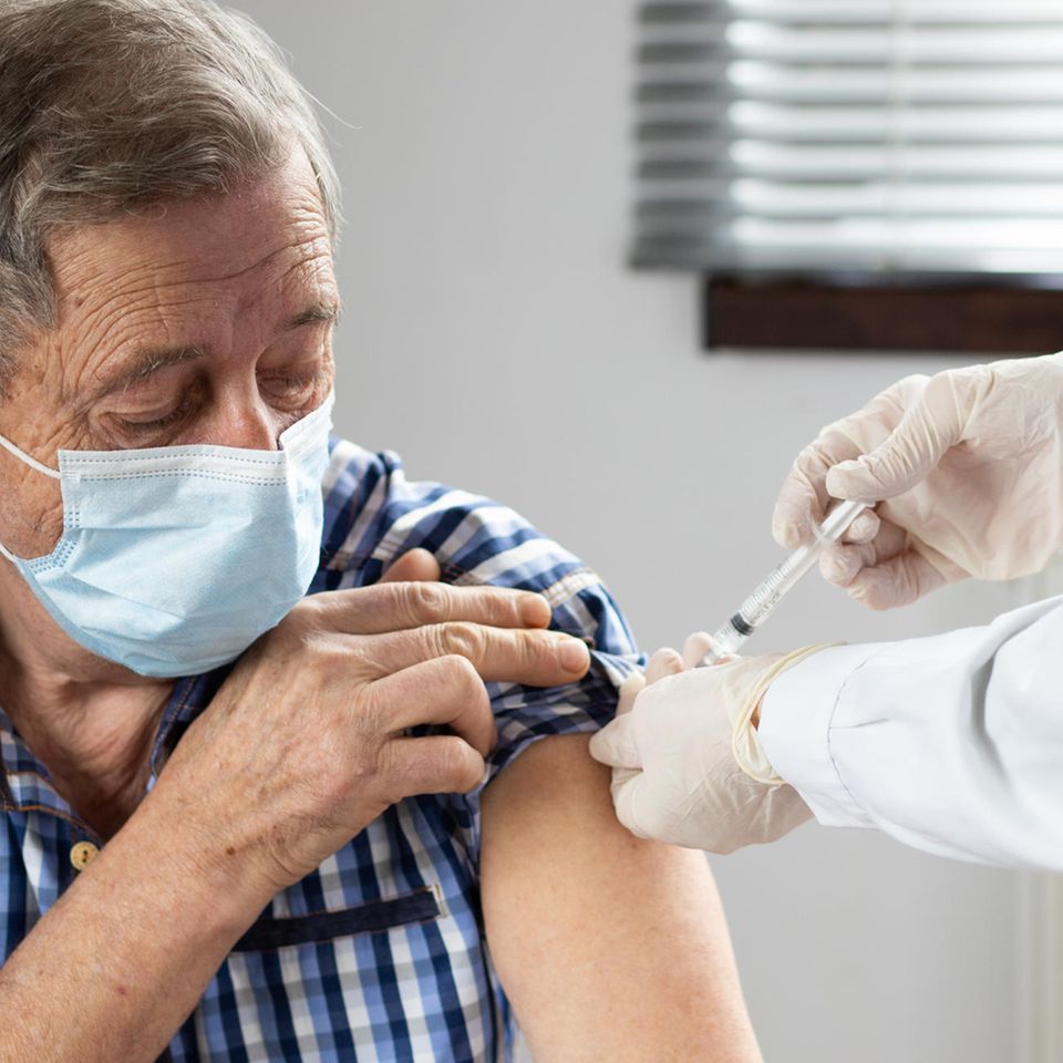 Mann wird in den Arm gegen Grippe geimpft