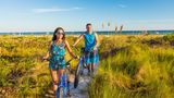 Glückliches Paar mit Fahrrädern am Strand von Sanibel Island, Florida