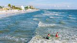 Teenager beim Surfen im Meer vor dem Fort Myers Beach in Florida