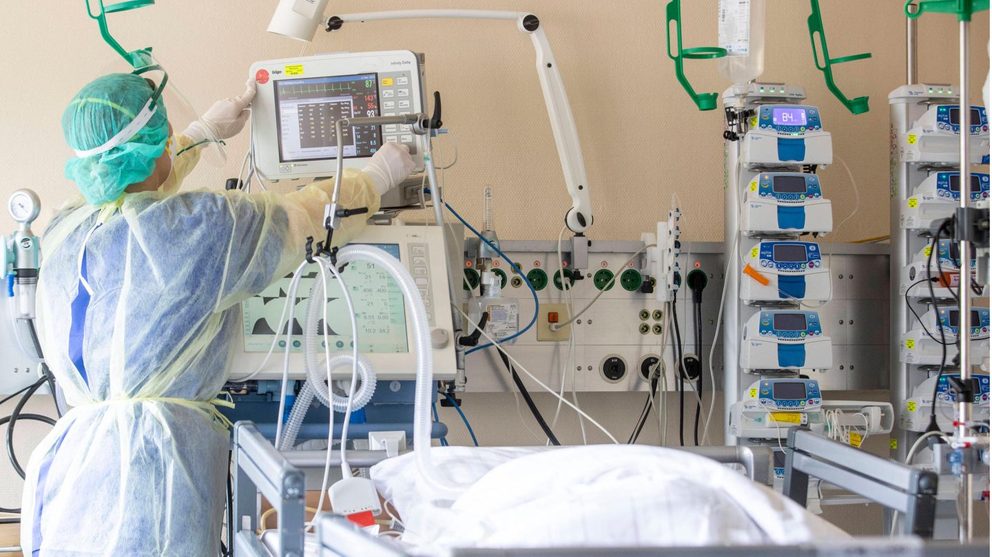 Eine Pflegerin versorgt eine im Koma liegende Corona-Intensivpatientin