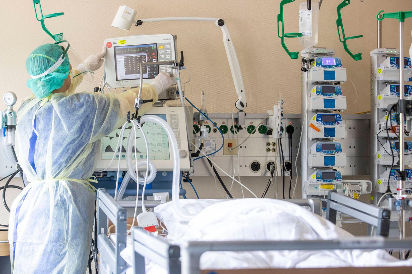 Eine Pflegerin versorgt eine im Koma liegende Corona-Intensivpatientin