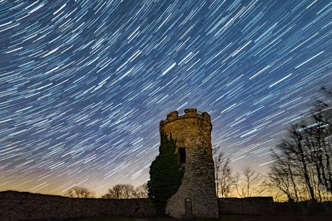 Durch Langzeitbelichtung werden die Sternenbahnen über der hessischen Burg Ebersburg sichtbar