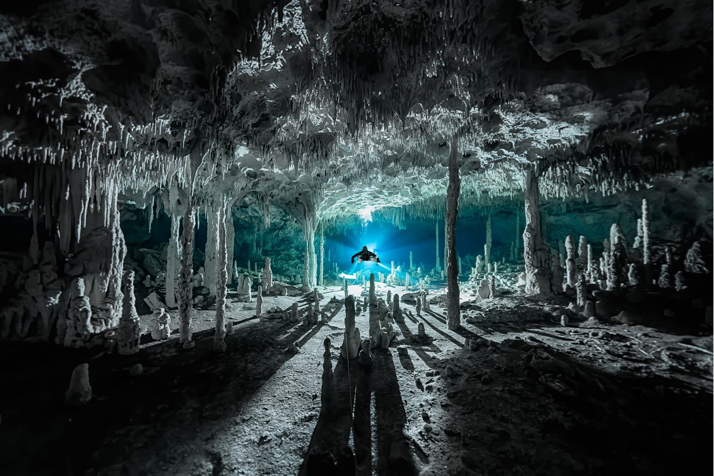 Märchenhaft wirkt die mexikanische Cenote Dos Pisos. Durch das Licht im Hintergrund werfen die Speläotheme, sekundäre Mineralablagerungen, lange Schatten. Martin Broen siegt  mit diesem Bild in der Kategorie "Exploration Photographer of the Year".