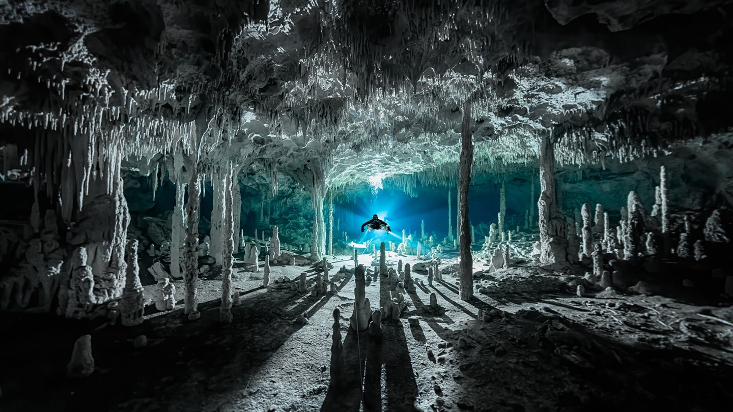 Märchenhaft wirkt die mexikanische Cenote Dos Pisos. Durch das Licht im Hintergrund werfen die Speläotheme, sekundäre Mineralablagerungen, lange Schatten. Martin Broen siegt  mit diesem Bild in der Kategorie "Exploration Photographer of the Year".