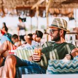 Mann trinkt Eiskaffee in einer Beach-Bar