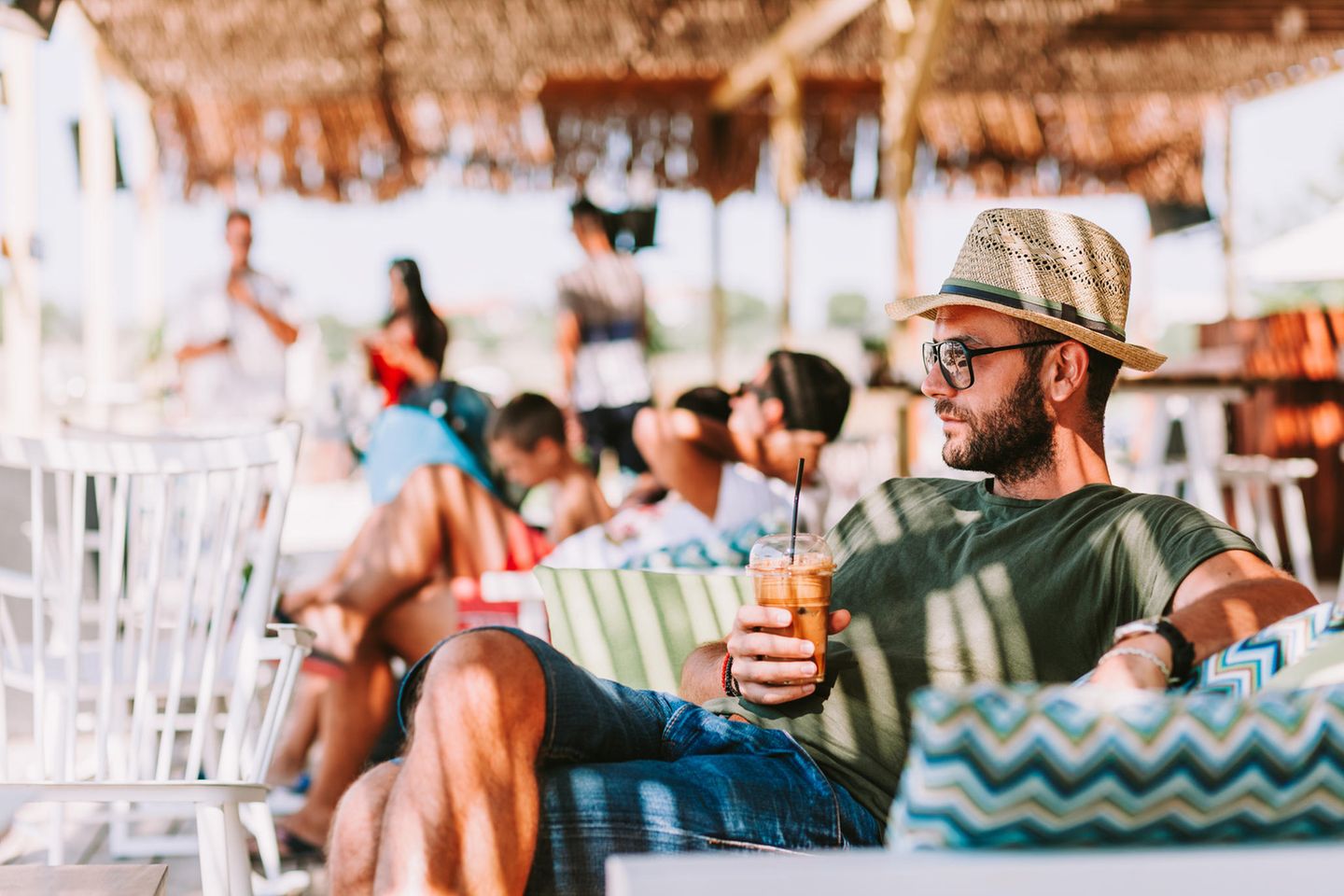 Mann trinkt Eiskaffee in einer Beach-Bar