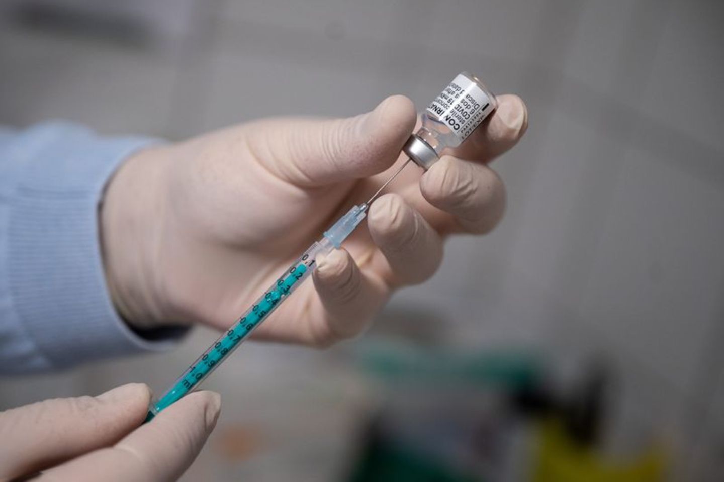 Ein Arzt zieht in einer Hausarztpraxis eine Spritze mit dem Impfstoff von Pfizer/Biontech auf