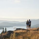 Ein Paar blickt beim Wandern vom Berg auf einen See