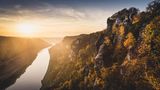 Basteibrücke in der Sächsischen Schweiz mit Herbstlaub und Sonnenuntergang