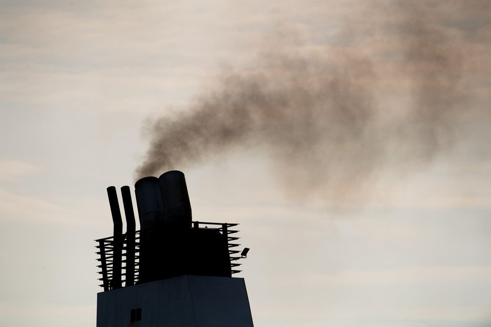 Eine Fähre stößt Abgase aus einem Schornstein aus. An der Klimakrise hat der Schiffsverkehr einen vergleichsweise großen Anteil