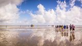 Wanderer im Wattenmeer bei Sonnenschein