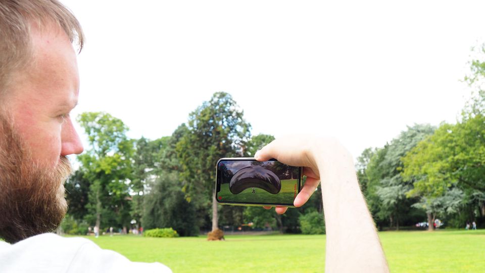 Felix sieht auf seinem Handy die Skulptur YOUar