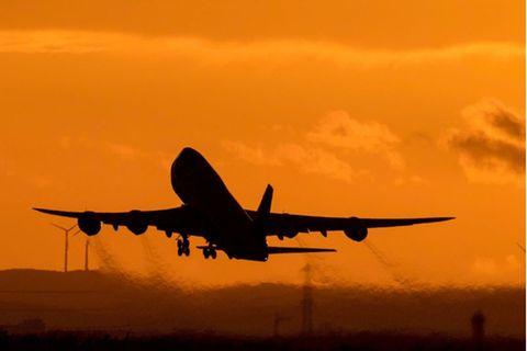 Ein Flieger hebt ab in den Sonnenuntergang am Flughafen Frankfurt