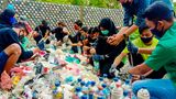 Die Dorfbewohnerinnen und -bewohner sor­tieren und trocknen den Plastikabfall. Dann stopfen sie ihn in Flaschen, bis diese proppenvoll und schwer wie Ziegelsteine sind.