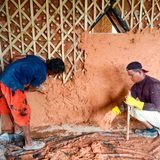 Dick aufgetragen: Zum Schutz vor Wind und Regen verputzen diese beiden Männer die Ecobrick-Mauern mit Lehm.