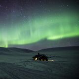 Mann fotografiert Nordlichter am Himmel über dem Dovrefjell-Sunndalsfjella-Nationalpark