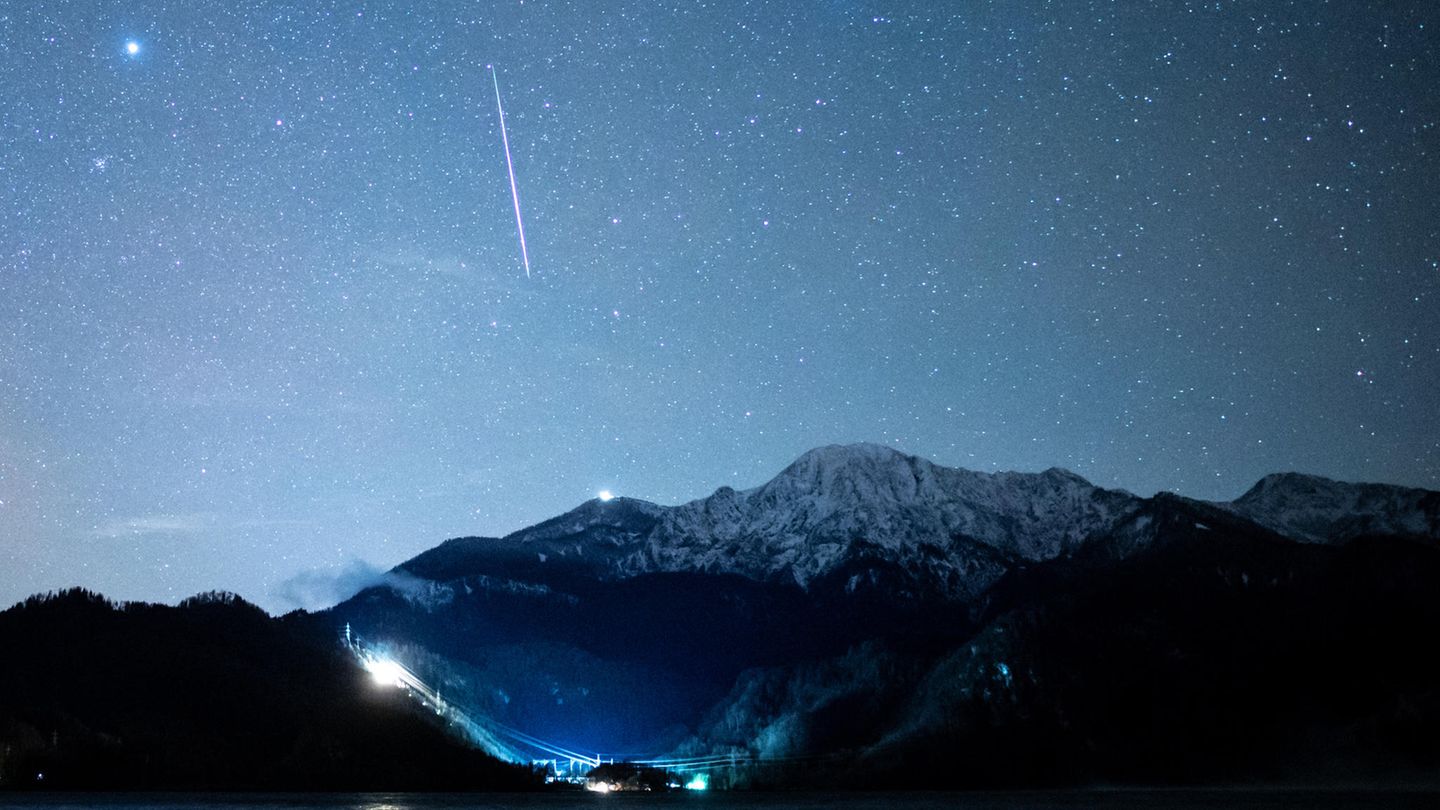 Eine Sternschnuppe ist während der Geminiden über dem Kochelsee zu sehen. Schaulustige haben bei klarem Nachthimmel im Dezember wieder die Chance auf ein Sternschnuppen-Spektakel