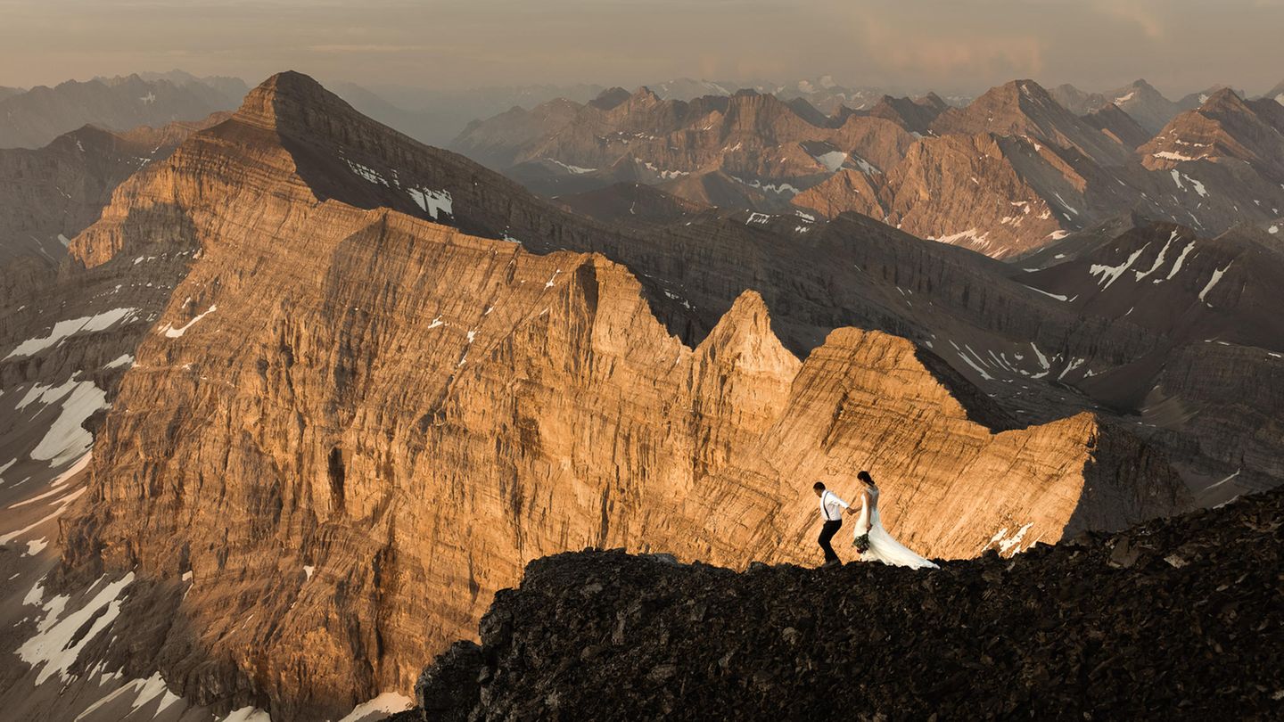 Wedding Photographer of the Year: Für die Fotografen Bec und Andrew von "Willow and Wolf" war der Hochzeitstag eines abenteuerlustigen Paares eine echte Herausforderung. Auf dem Berggipfel in 3048 Metern Höhe hatte sich das Paar verlobt und wollte am Tag der Vermählung diesen besonderen Ort wieder besuchen. "Dieses eine Bild fasst die Beziehung zusammen, die sie auf der Jagd nach Abenteuern und ihrer Liebe zueinander in den Bergen aufgebaut haben", schreiben die Fotografen. Wedding Photographer of the Year: Für die Fotografen Bec und Andrew von "Willow and Wolf" war der Hochzeitstag eines abenteuerlustigen Paares eine echte Herausforderung. Auf dem Berggipfel in 3048 Metern Höhe hatte sich das Paar verlobt und wollte am Tag der Vermählung diesen besonderen Ort wieder besuchen. "Dieses eine Bild fasst die Beziehung zusammen, die sie auf der Jagd nach Abenteuern und ihrer Liebe zueinander in den Bergen aufgebaut haben", schreiben die Fotografen.