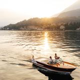 Wedding Photographer of the Year: Wasser ist für viele Menschen ein ganz besonderes Element. EL Andrew hat dieses Paar festgehalten, als es mit dem Boot auf einem See entlang fährt, während die Sonne sich wunderschön spiegelt. Landschaft und Brautpaar verschmelzen in einer romantischen Szene.