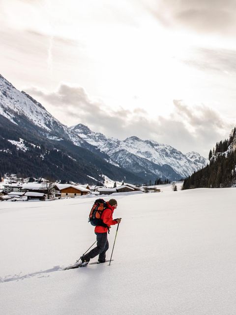 Die frischen Flocken, die der Wind heranpeitscht, piksen auf der Haut wie Nadelstiche – und machen den Wanderern Beine