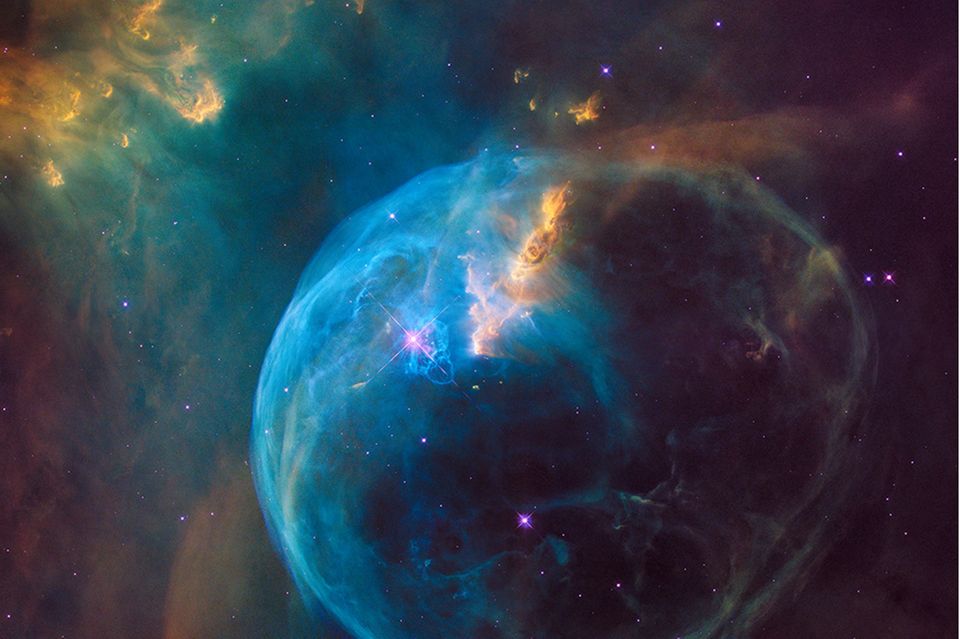 Kosmischer Kreislauf: Hier schleudert ein junger Stern (Mitte, etwa bei zehn Uhr, glitzernd) gewaltige Mengen an Gas (blau) ins All. Darunter auch Substanzen, die zuvor in seinem Inneren entstanden sind und nun als Rohmaterial für neue Himmelskörper dienen
