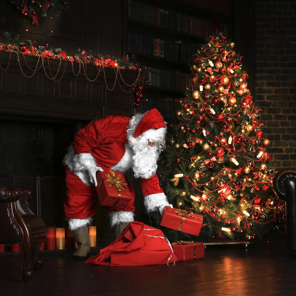 Der Weihnachtsmann legt Geschenke unter den Baum