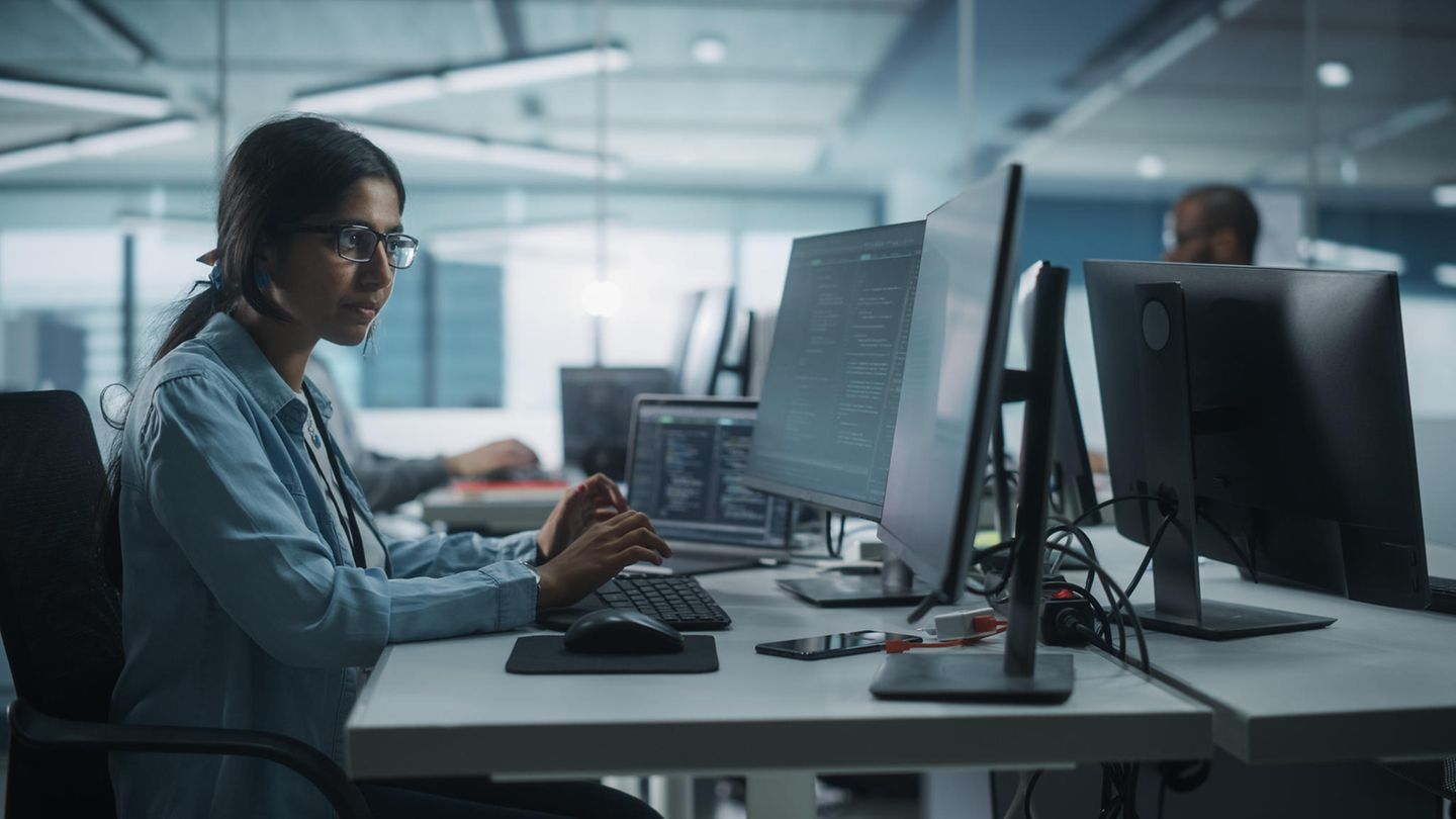 Eine junge Frau indischer Abstammung arbeitet an einem Computer